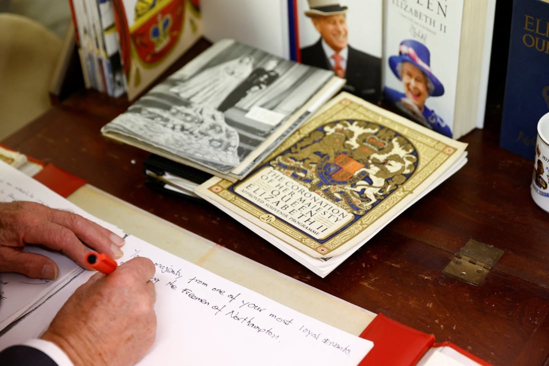 A person writes condolences on the papers that will make a book of remembrance, following the death of Britain’s Queen Elizabeth. Photo: Reuters