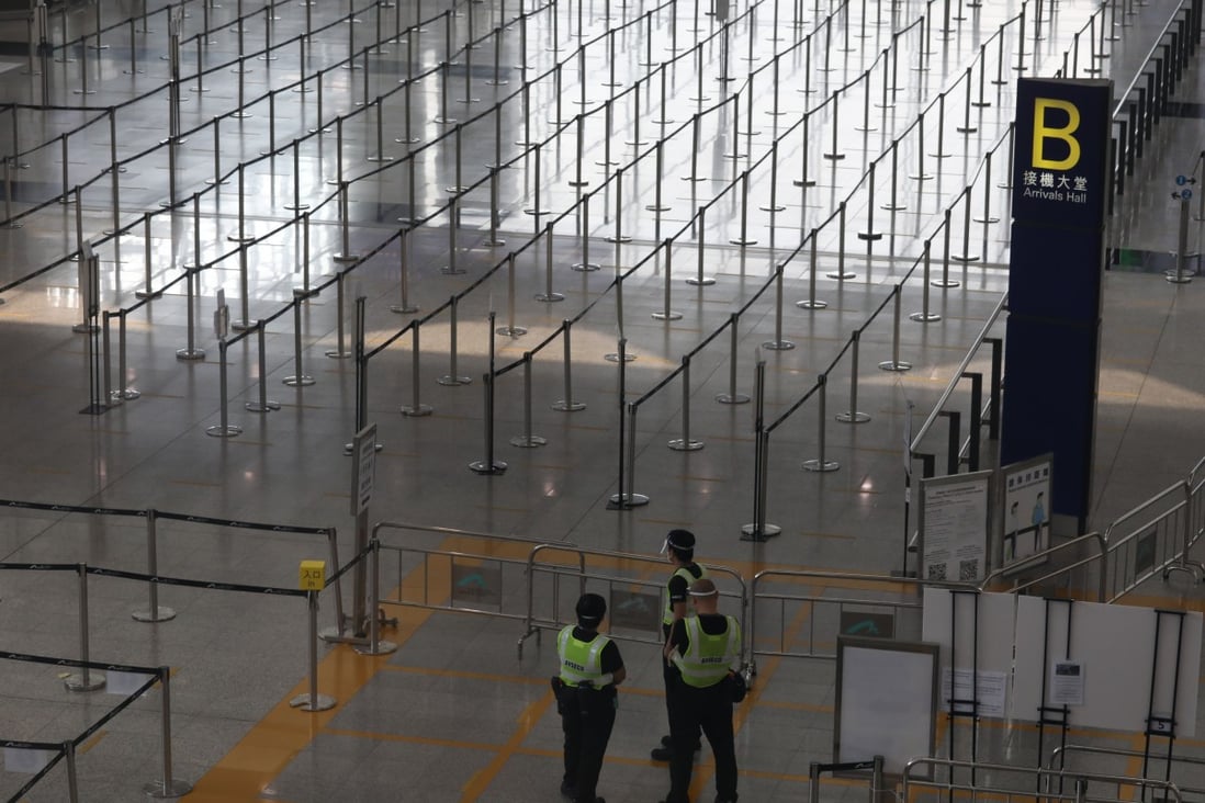 Security guards chat in an empty arrivals hall at Hong Kong International Airport on September 10. Despite sustained calls to fully reopen Hong Kong’s borders, pandemic restrictions remain in place and continue to weigh on the city’s attractiveness, competitiveness and economy. Photo: Yik Yeung-man