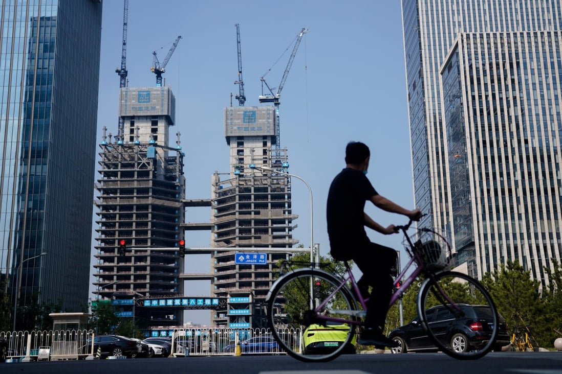 A man rides a bike past developments under construction in Beijing on September 15. Photo: EPA-EFE
