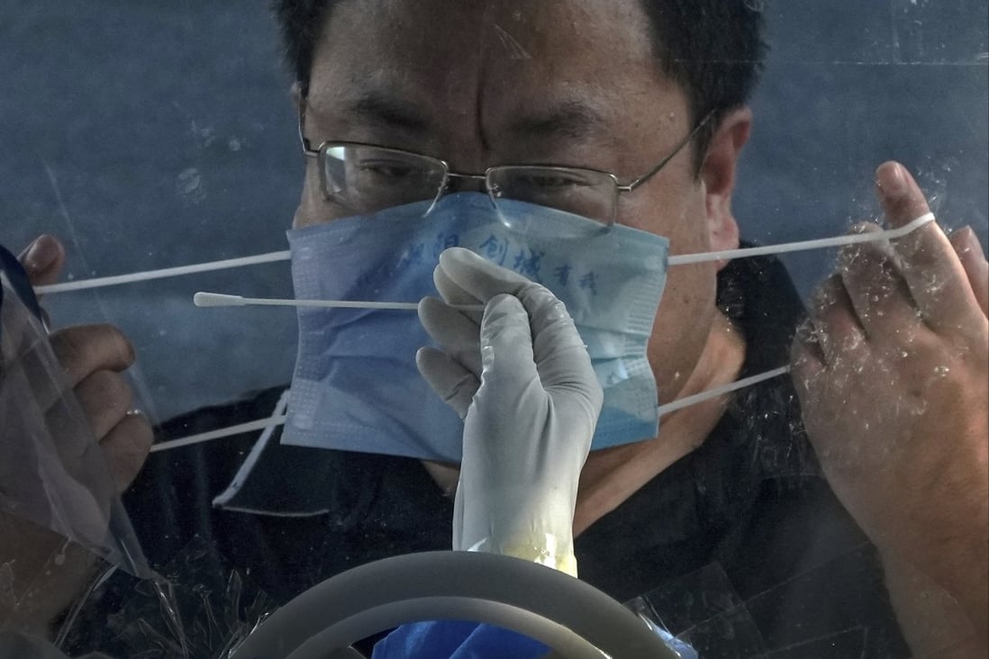 A man removes his face mask for a throat swab at a coronavirus testing site in Beijing. Chinese researchers say their new smart mask could help prevent future outbreaks of respiratory diseases. Photo: AP
