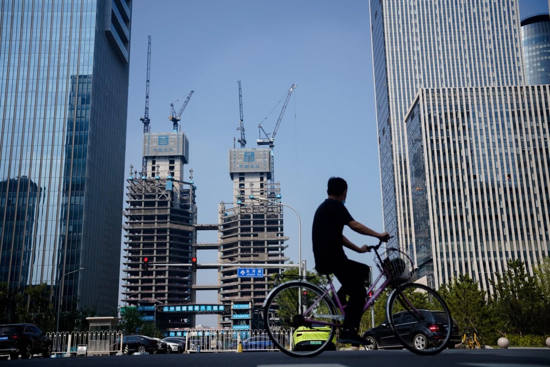 A man rides a bike along residential and commercial properties in Beijing in September 2022. Photo: EPA-EFE