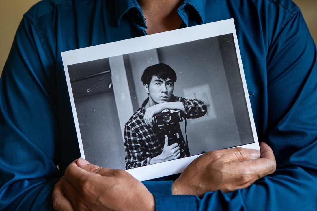 Hualun Wang, father of Peng Wang, holds a portrait of his son. Photo: TNS