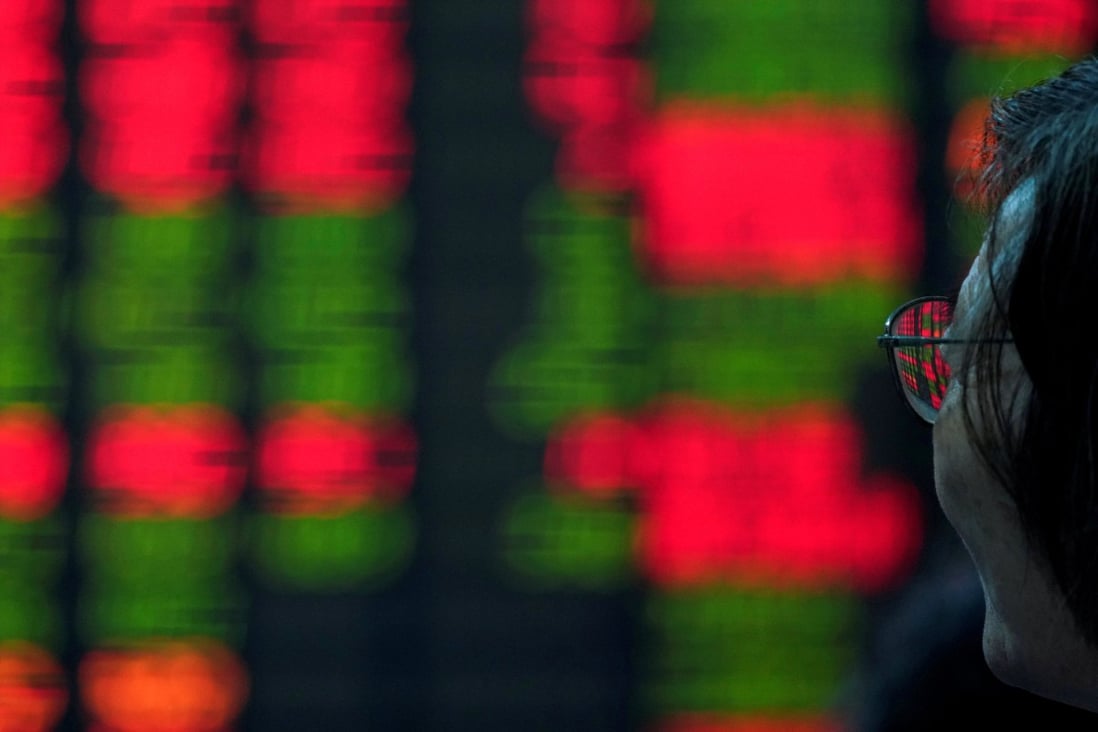 An investor looks at an electronic board showing stock information at a brokerage in Shanghai. Photo: Reuters
