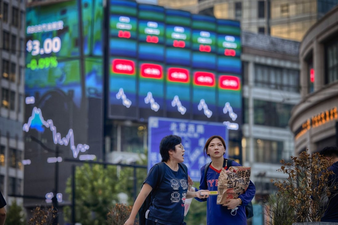 People walk past a large screen showing the latest stock exchange data in Shanghai on August 22, 2022. Combined trading volume on the Shanghai and Shenzhen on Wednesday shrank to a level not seen since October 27, 2020. Photo: EPA-EFE