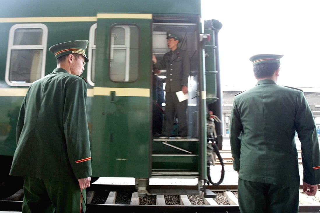 A North Korean railway guard stands aboard a train as it passes Chinese military police officers in Dandong in 2004. Photo: AP