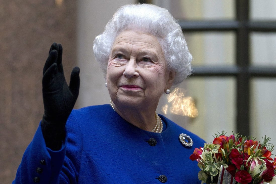 Britain’s Queen Elizabeth looks up and waves to members of staff of The Foreign and Commonwealth Office in London during an official visit in December 2012. Photo: AP