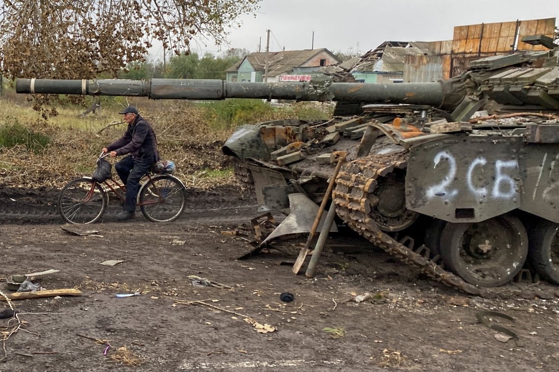 A local resident rides past an abandoned Russian tank in the village of Kurylivka, in the Kharkiv region of Ukraine, on October 1. Photo: Reuters