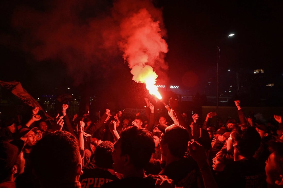 Fans chant during a candlelight vigil for victims of the stadium stampede that killed at least 125. Photo: AFP