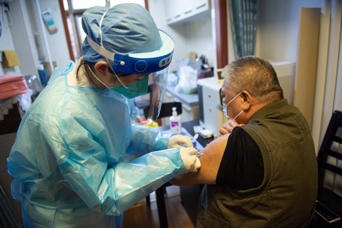 An elderly Beijing resident gets vaccinated by a health worker at his home in May. Photo: Xinhua