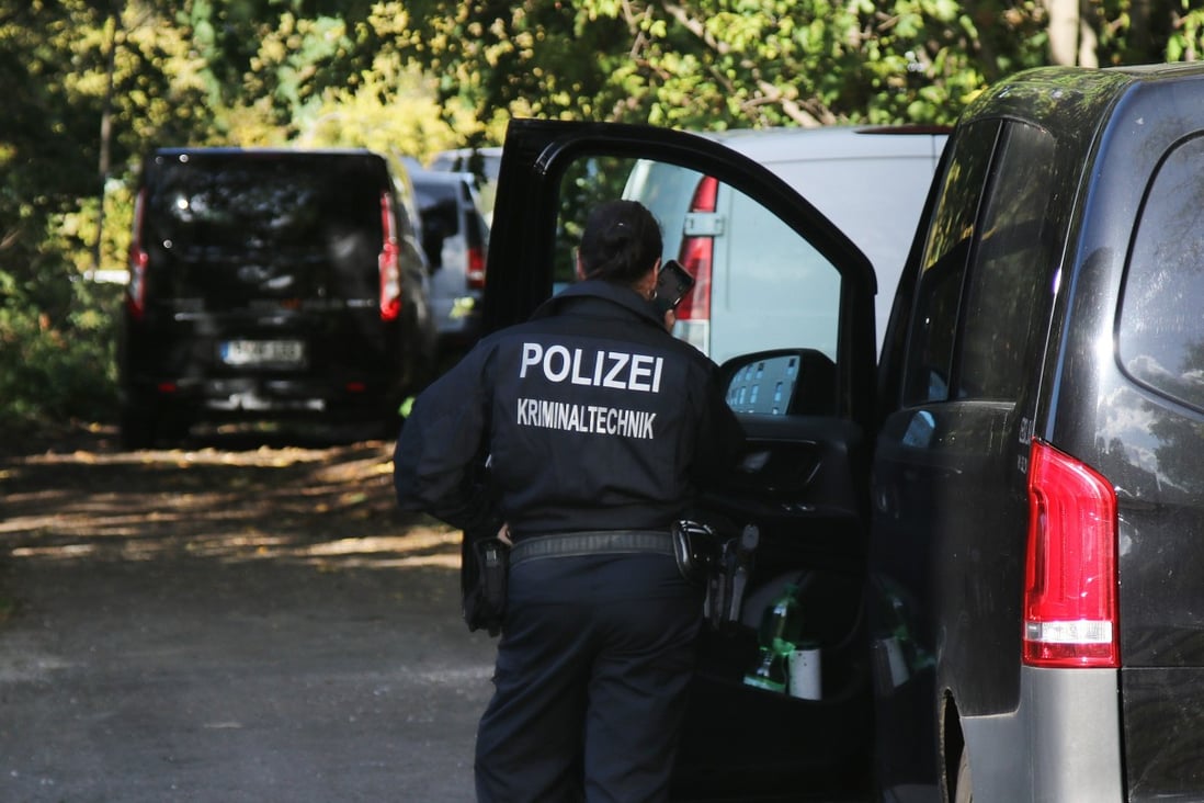 A forensic police officer stands next to police vehicles near a German railway station. State security services have taken the lead in investigating the apparent sabotage of train lines in northern Germany that brought transport to a halt for hours. Photo: dpa