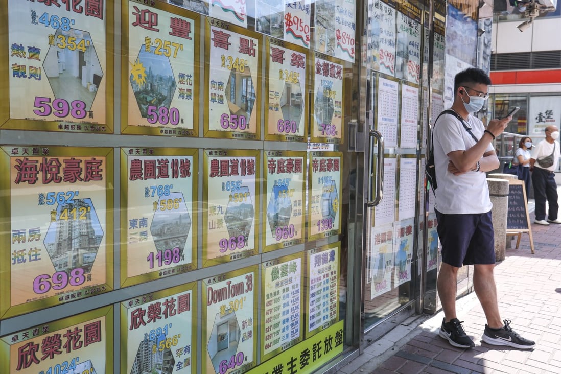 A man walks stands near residential property advertisements displayed in To Kwa Wan on October 7, 2022. Photo: SCMP/ Edmond So