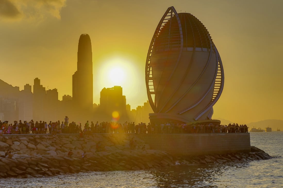 People take photographs of the sunset at East Coast Park Precinct, along the waterfront in Fortress Hill. Victoria Harbour, one of the world’s renowned deepwater harbours, has been preserved for the enjoyment of Hongkongers since 1997. Photo: Dickson Lee
