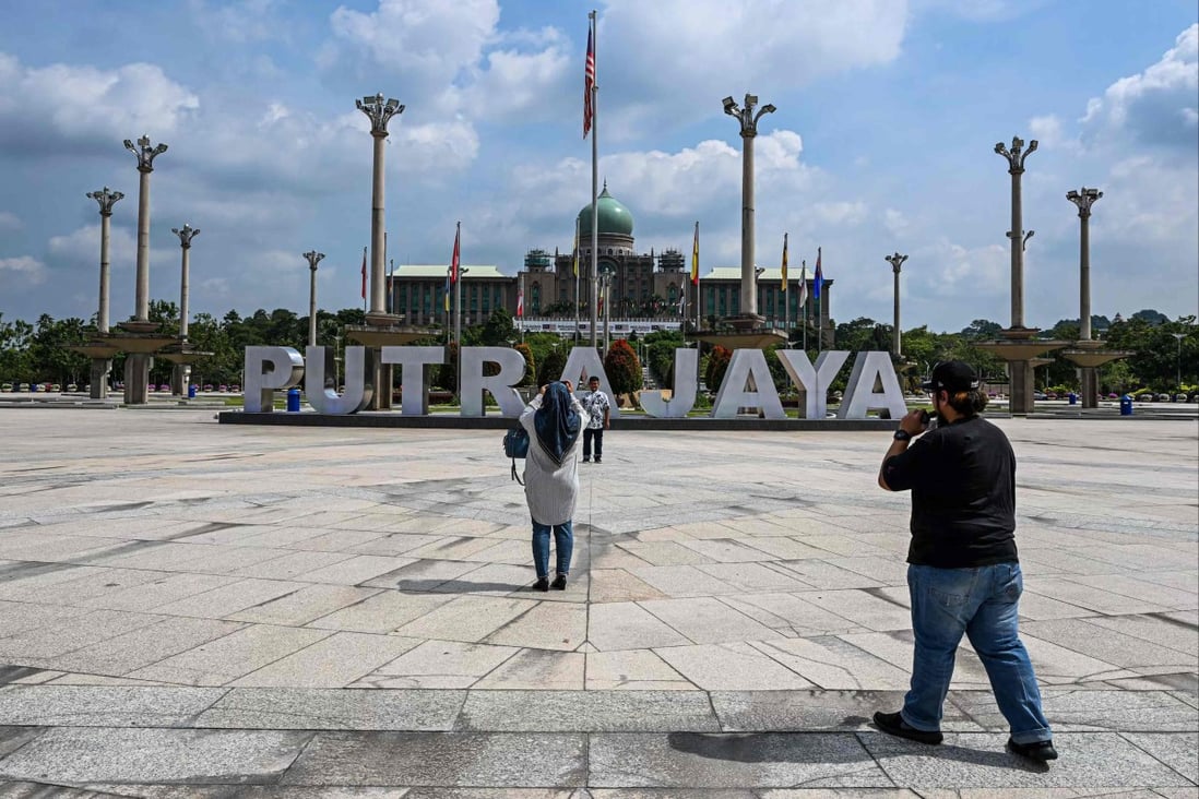 People take photos next to the office complex of the Malaysian prime minister in Putrajaya. The last two years have been the most turbulent in Malaysian politics with the rise and fall of three premiers and an economy only just recovering from the coronavirus pandemic. Photo: AFP