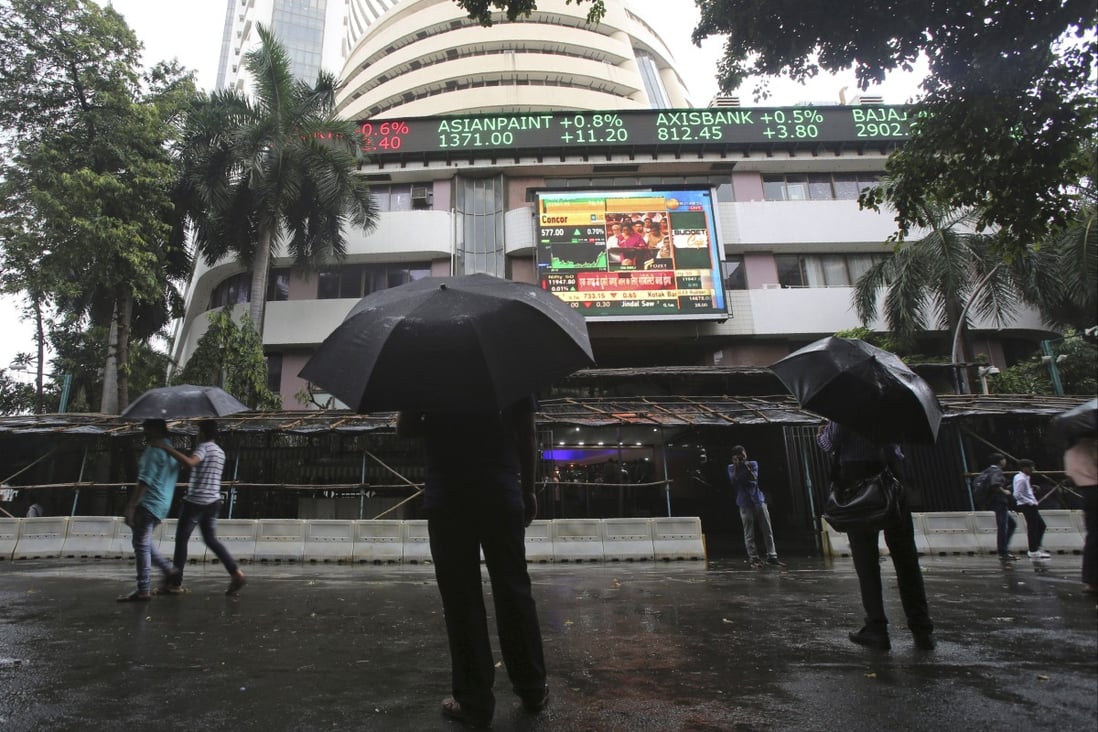 People watching the stock market index on the facade of the Bombay Stock Exchange building in Mumbai. Photo: AP