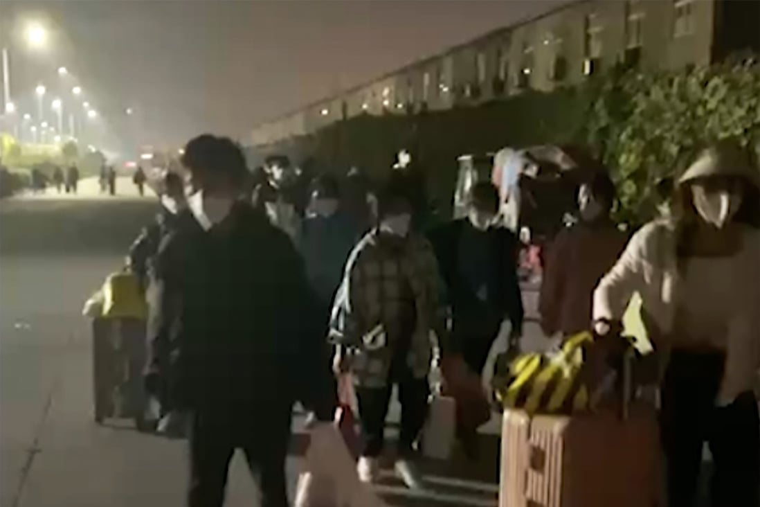 In this photo captured from video footage, people with suitcases and bags are seen leaving a Foxconn compound in Zhengzhou, Oct. 29, 2022. Photo: Hangpai Xingyang via AP