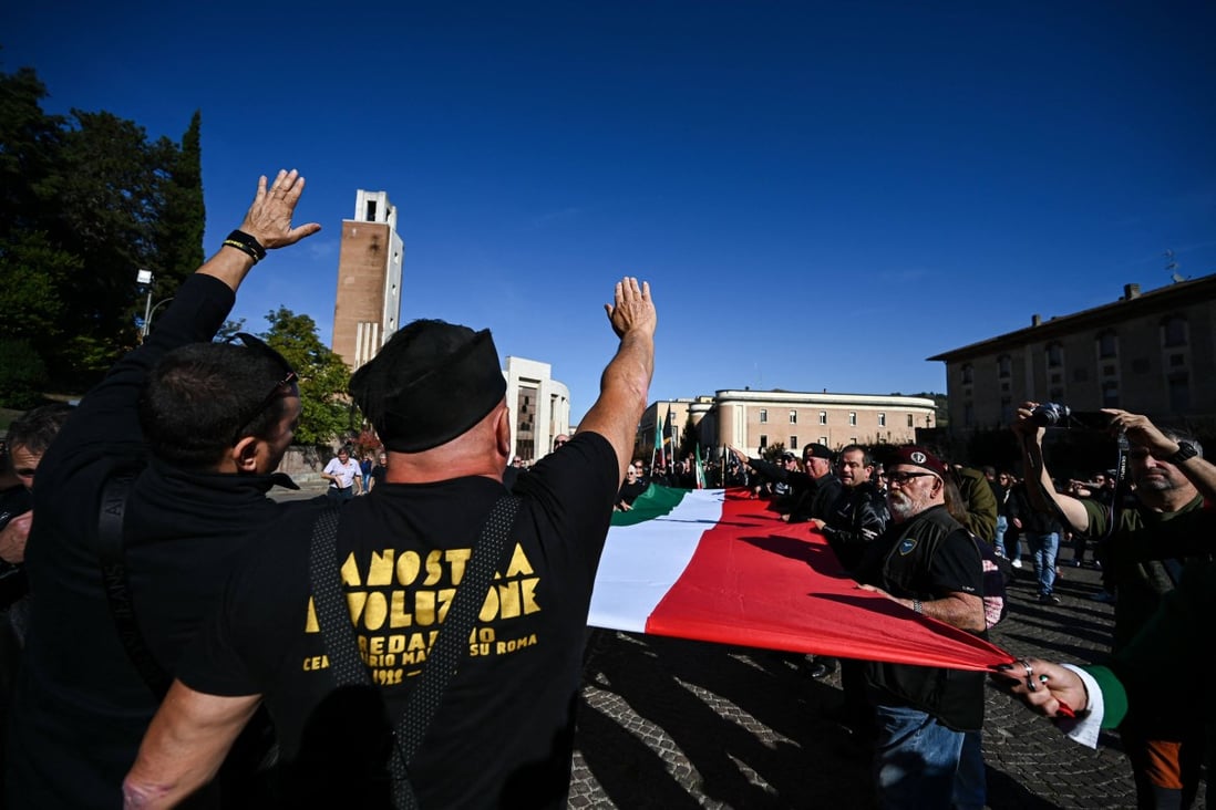 Participants gesture the roman salute during a march to the San Cassiano cemetery, the burial place of Benito Mussolini in Italy on Sunday. Photo: AFP