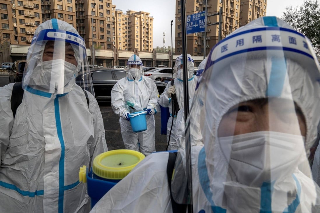 Workers in protective gear at a locked down neighbourhood in Beijing. Photo: Bloomberg