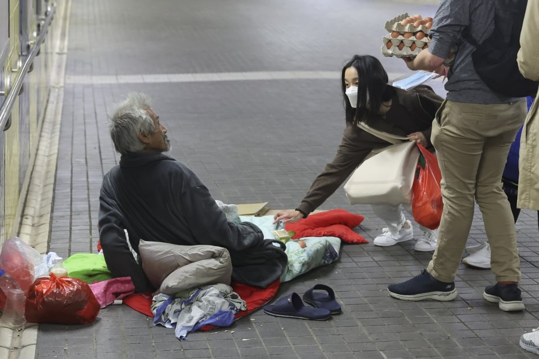 A street sleeper in Tsim Sha Tsui, Hong Kong, is provided with necessities during a “kindness walk” led by Alex Wong (second left) and organised through the homeless charity ImpactHK. Photo: Edmond So