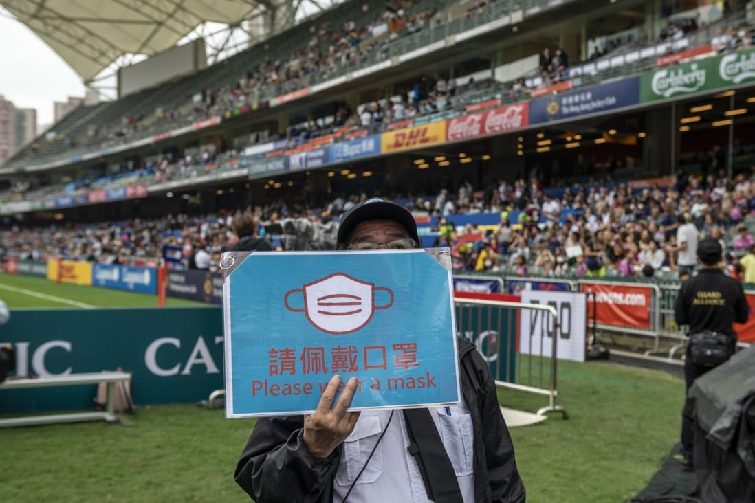 A security guard holds up a sign asking attendees to wear a face mask during the second day of the Hong Kong Sevens rugby tournament in Hong Kong on November 5. Photo: AP