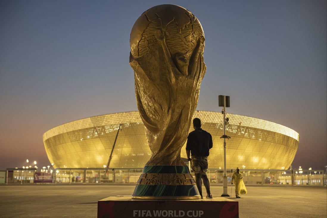 A man with a replica of the World Cup outside Lusail Stadium ahead of the World Cup. Photo: Reuters