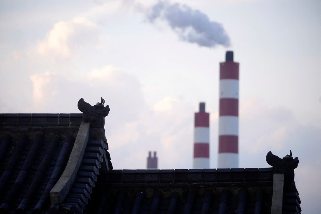 Chimneys of a coal-fired power plant are seen behind a gate in Shanghai on October 21, 2021. Photo: Reuters