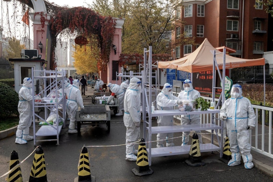 Workers in protective gear at a neighborhood placed under lockdown due to Covid-19 in Beijing on November 10. Photo: Bloomberg