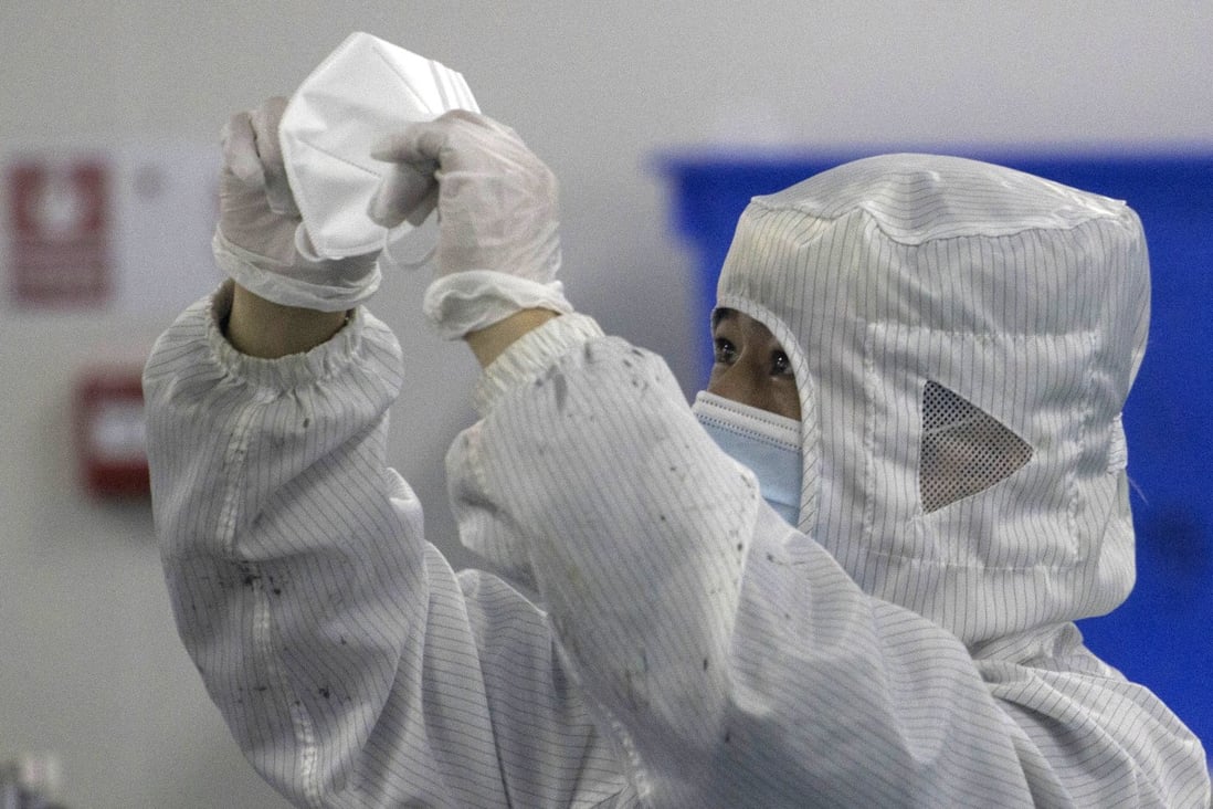 A worker examines a mask produced in a clean room production line in Wuhan in April 2020. Photo: AP