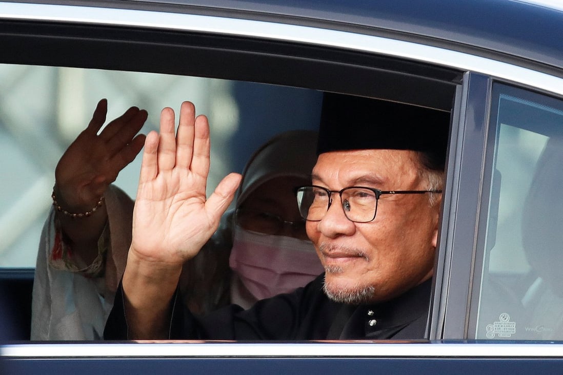New Prime Minister Anwar Ibrahim waves as he arrives at the National Palace on Thursday. Photo: Reuters