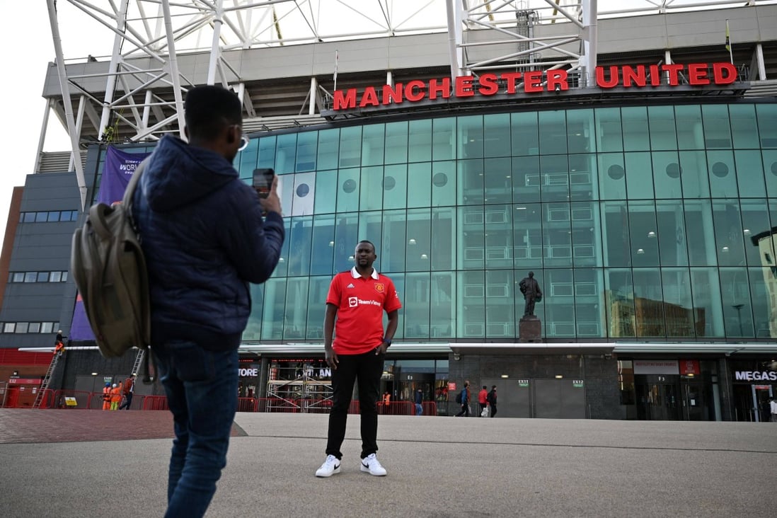 A fan poses for a photograph outside Old Trafford stadium, the home of Manchester United. Photo: AFP