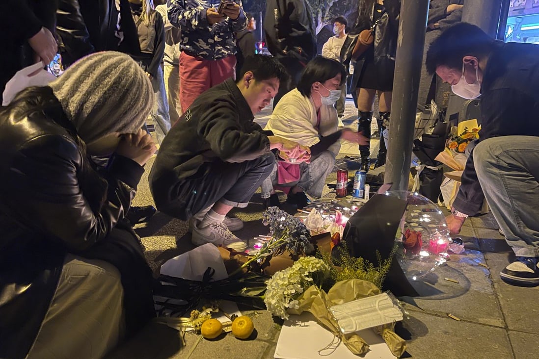 Residents pay tribute in Shanghai on Saturday to victims of a recent deadly fire in Xinjiang. Photo: AP