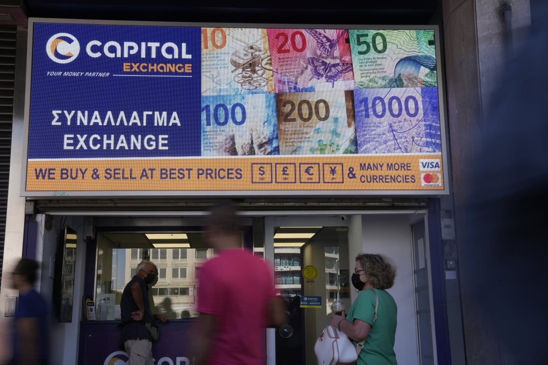 People wait at a currency exchange office as pedestrians walk at Omonia square in Athens, Greece, on July 13. The euro appears set for a comeback on the global exchanges only a few months after falling to parity with the US dollar for the first time in nearly 20 years. Photo: AP