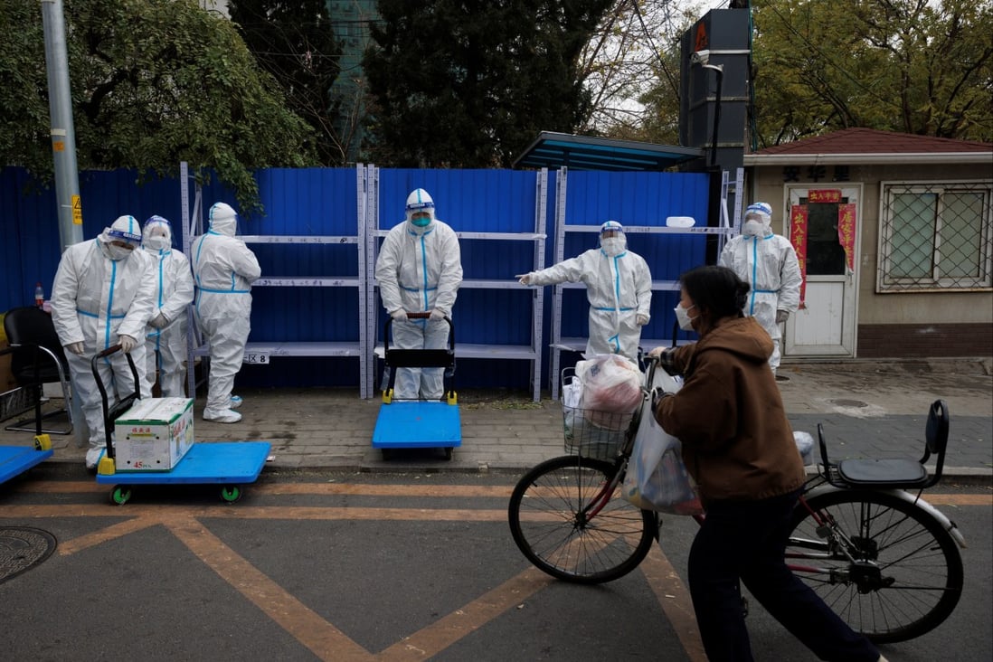 A woman delivers food to a residential compound under lockdown on Monday as Covid-19 outbreaks continue in Beijing. Photo: Reuters