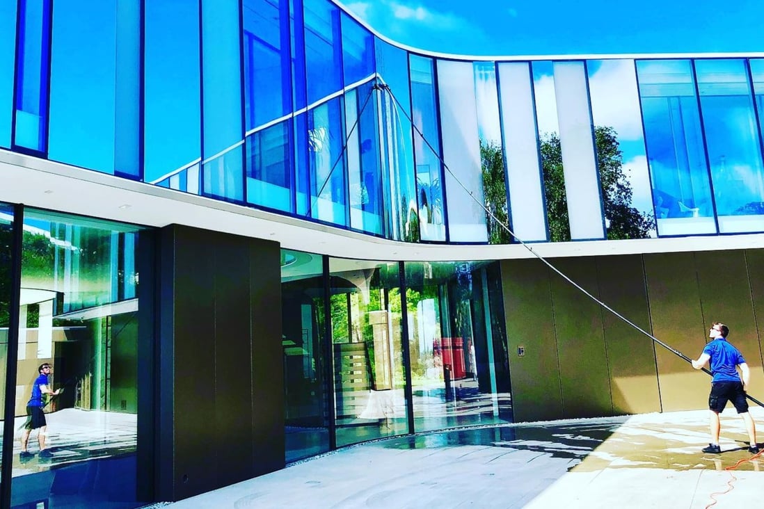 A cleaner for LA Elite Window Cleaning washes the exterior of a mega-mansion in Bel-Air, Los Angeles. Photo: Facebook / LA Elite Window Cleaning