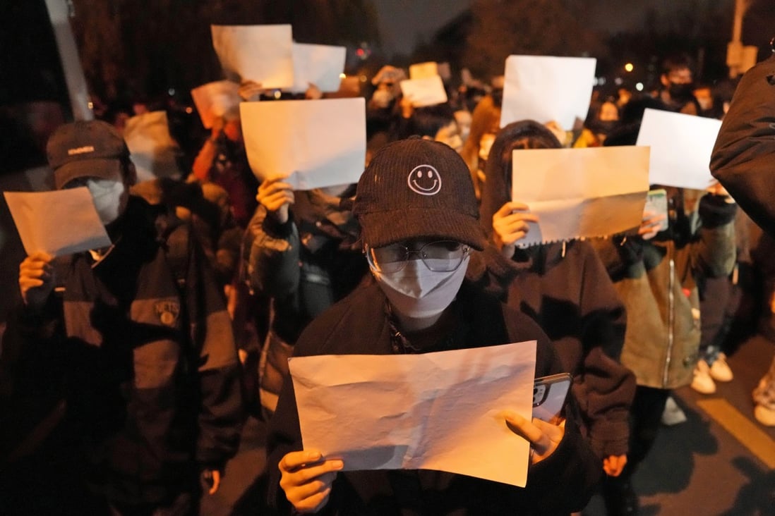 Protesters hold up blank papers in a protest in Beijing on Sunday. Photo: AP