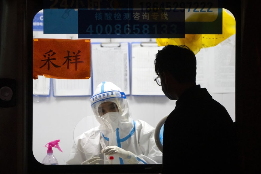 A worker in a protective suit waits to administer Covid-19 tests in Beijing in November. Photo: AP