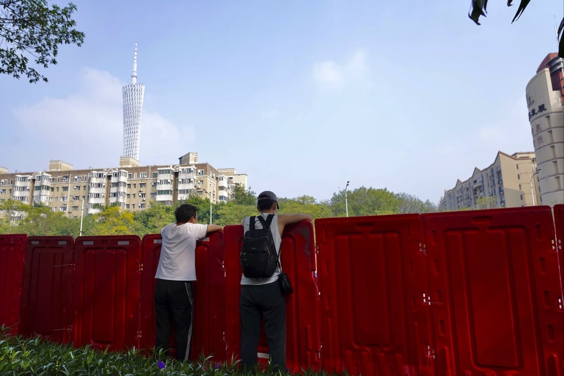 Residents look out from barriers around locked down Haizhu district in Guangzhou last month. Photo: AP