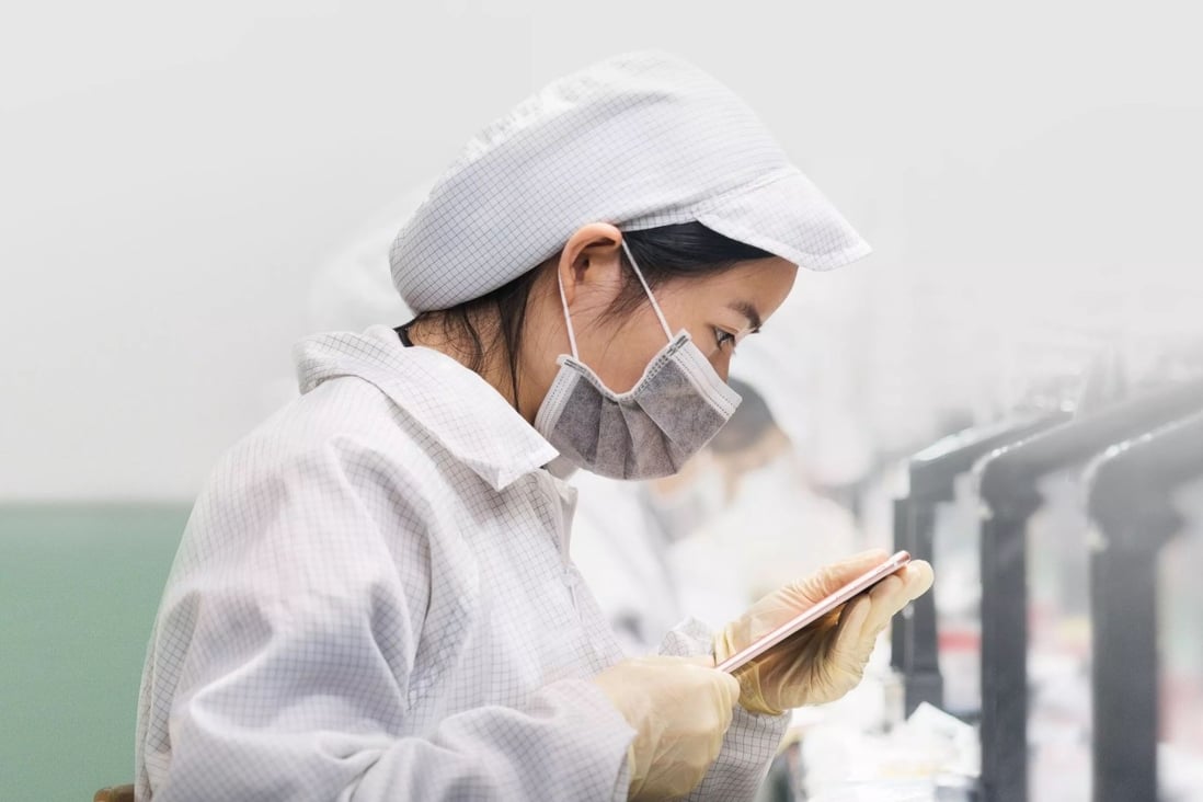 A Foxconn Technology Group employee is seen inspecting an iPhone at an assembly line inside the firm’s manufacturing complex in Zhengzhou, capital of central Henan province. Photo: Shutterstock