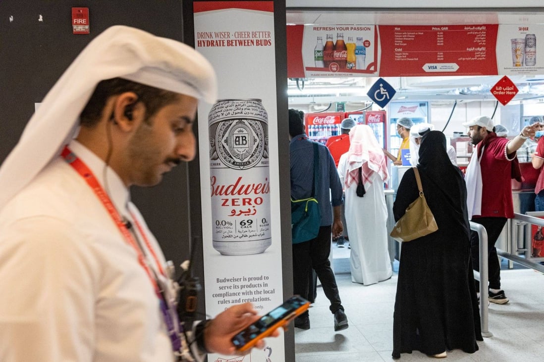 An Anheuser-Busch Budweiser Zero brand beer advertisement as customers wait at a food stand ahead of the first match of the FIFA World Cup at Al Bayt Stadium in Al Khor, Qatar on November 20. Rigid limits on alcohol are a fact of life in this conservative Muslim nation on the Arabian Peninsula, which follows the same strict Wahhabi interpretation of Islam as its neighbour Saudi Arabia. Photo: Bloomberg
