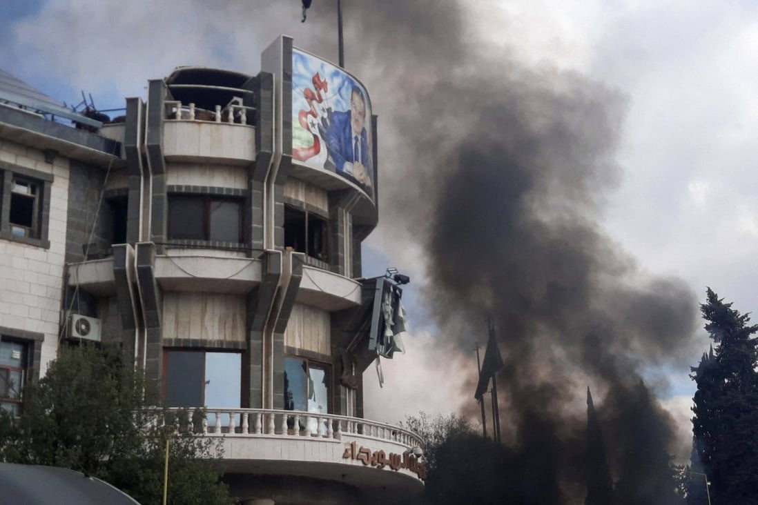 Smoke billows during a rally to protest deteriorating living conditions in front of the governorate building in Suwaida, southern Syrian on Sunday. Photo: SUWAYDA24 / AFP