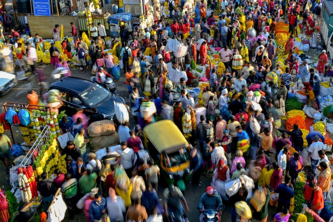 People walk through a market in Bangalore, India, on October 23. India is set to overtake China as the world’s most populous country next year. Photo: AFP