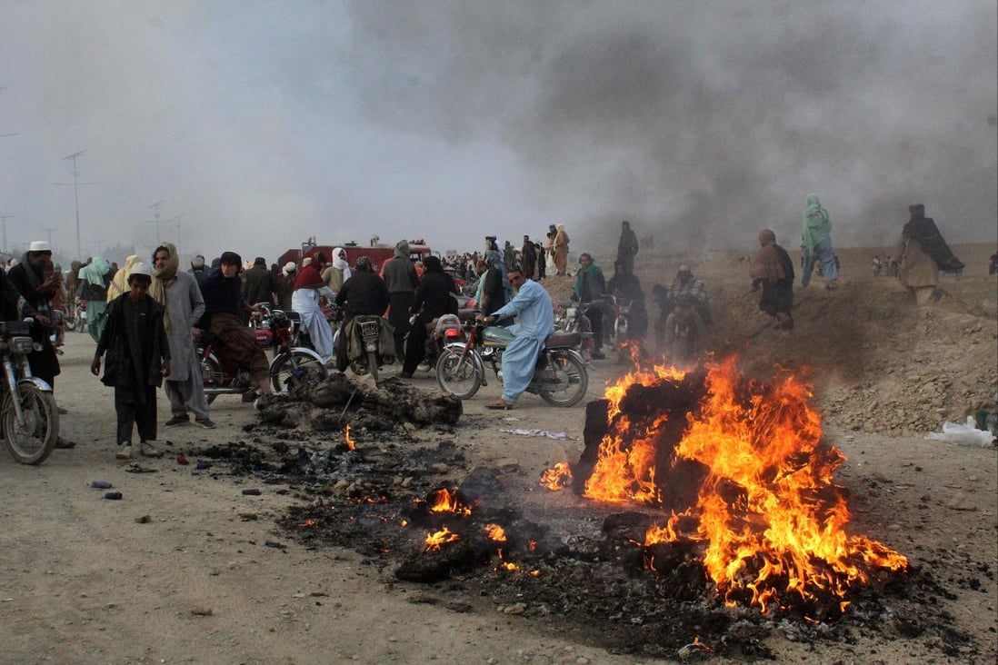 People gather near flaming wreckage caused by Afghan Taliban forces’ mortar fire in Pakistan’s border town of Chaman on Sunday. Photo: AFP