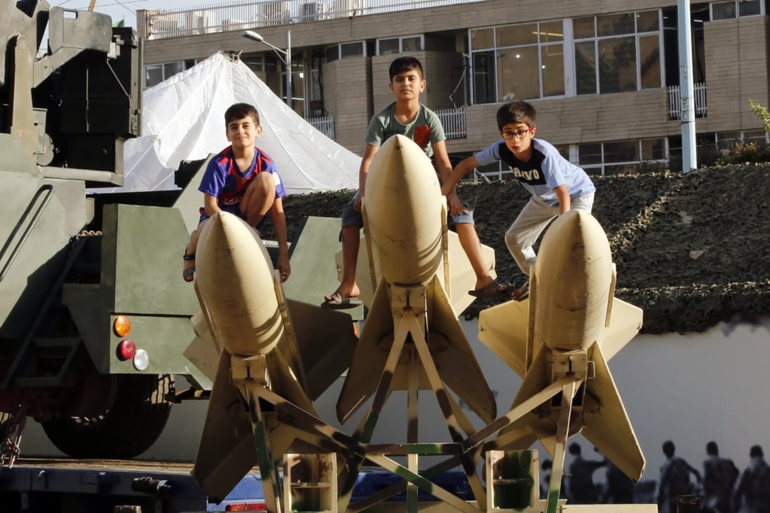 Iranian children sit on short-range missiles in a street exhibition by Iran’s army and paramilitary Revolutionary Guard. File photo: EPA-EFE