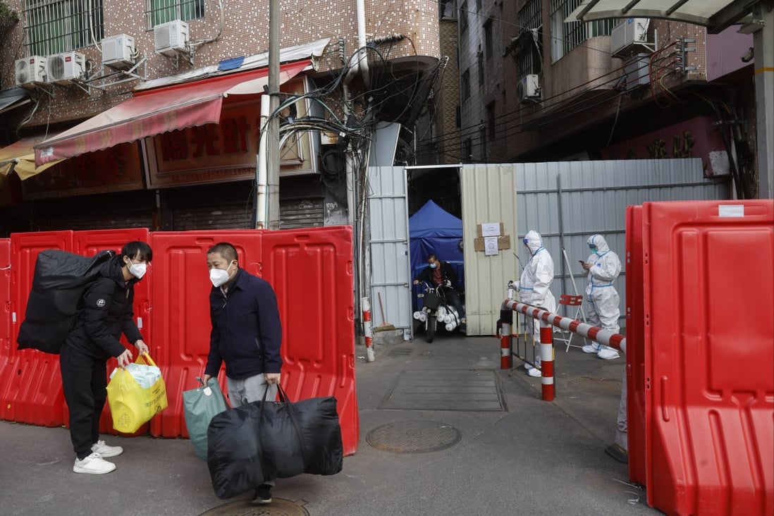Migrant workers with their belongings leave a barricaded village after authorities ease Covid curbs in Guangzhou. Photo: AP