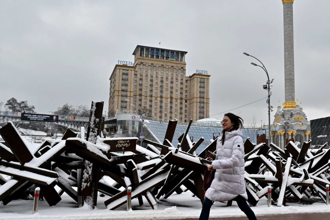 A woman walks past anti-tank steel hedgehogs covered with snow in Kyiv. Photo: AFP 