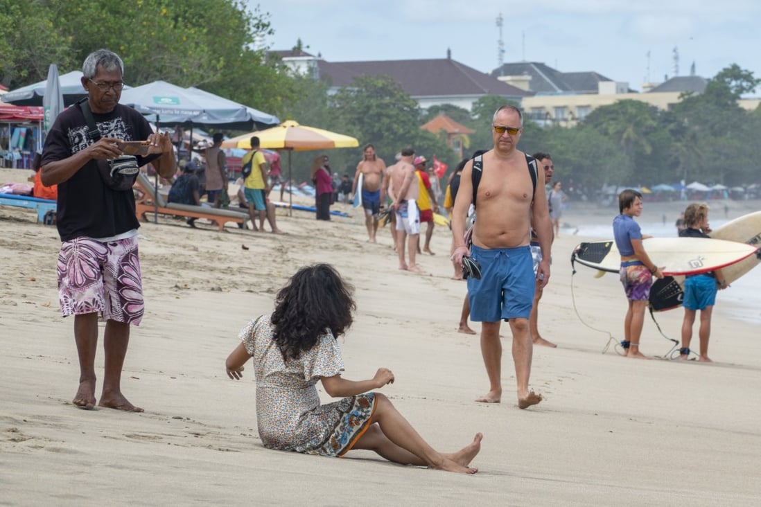 An older Westerner walks along a beach in Bali. Indonesia hopes its new second-home visa programme will entice billionaires and millionaires, but the retirees already living there feel like they’ve been left in the lurch. Photo: EPA-EFE