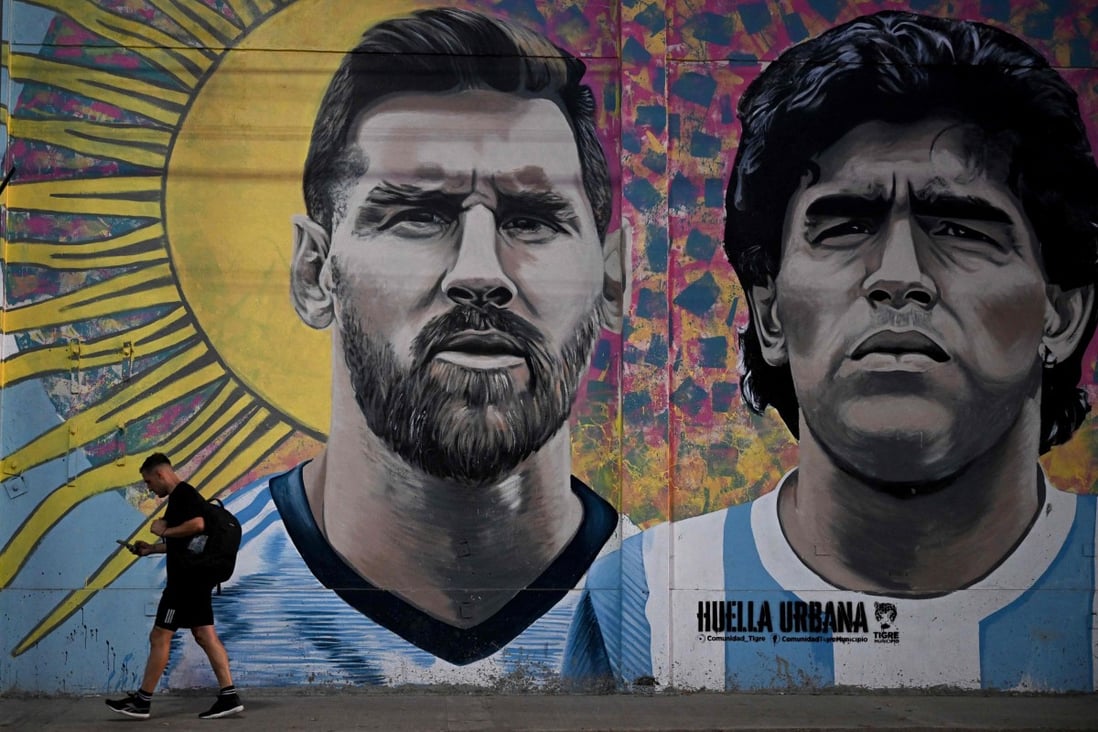 A man passes by a mural in Buenos Aires depicting Argentine football stars Lionel Messi (left) and the late Diego Maradona on the eve of the World Cup final. Photo: AFP