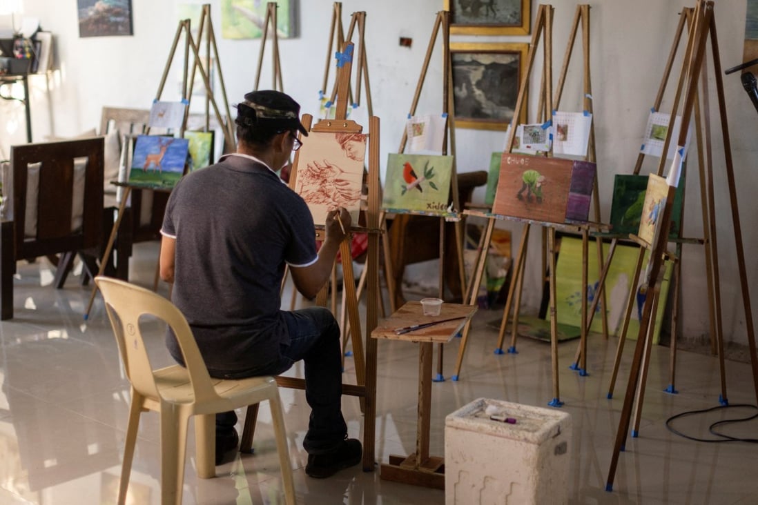 Filipino artist Elito Circa, 52, paints using his blood in his studio in Nueva Ecija province, Philippines. Photo: Reuters