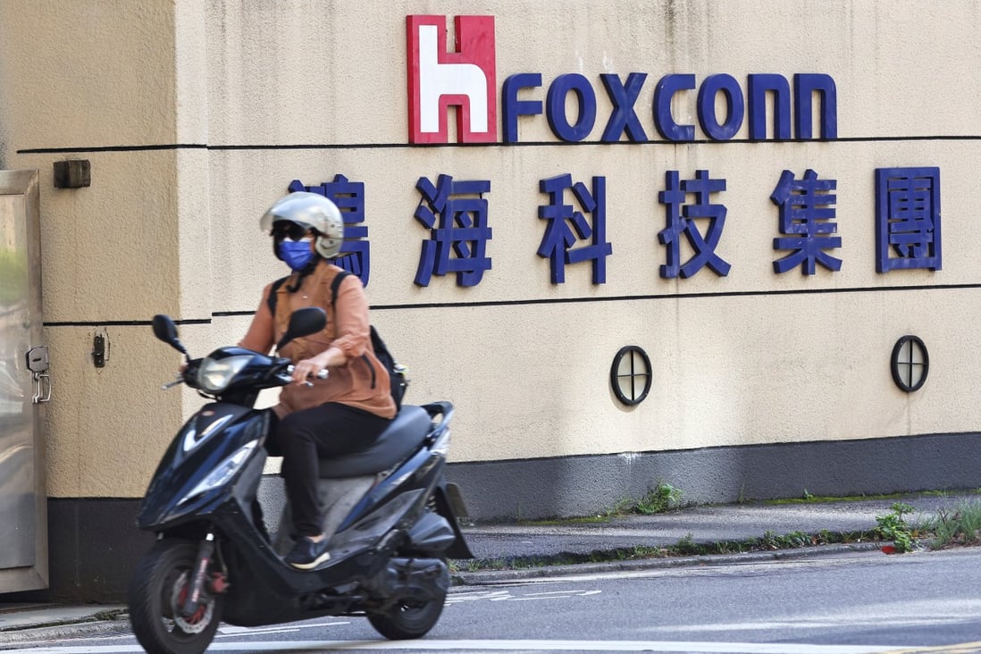 A woman drives past the logo of Foxconn Technology Group outside the company’s building in Taipei. Photo: Reuters
