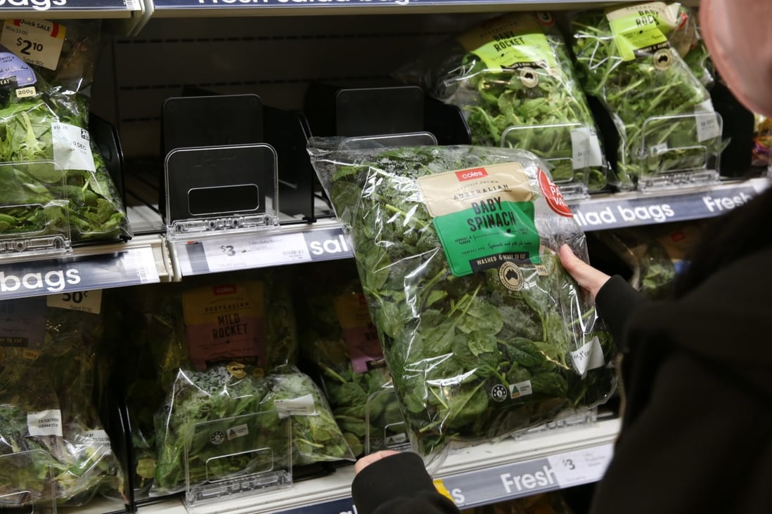 A customer looks at baby spinach in a supermarket in Sydney. Australians who ate contaminated spinach have described feeling dizzy or unable to stand, having blurred vision, and struggling to breathe normally. Photo: Xinhua