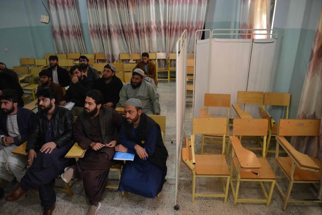 Male students in Kandahar Province attend a university class, where a curtain normally would separate them from women, who have now been banned. Photo: AFP